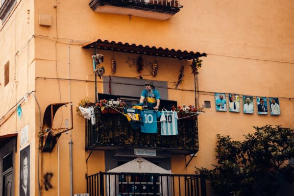A balcony decorated with football jerseys and player photographs, showcasing a tribute to soccer legends.